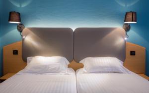 卡罗普罗莫特尔酒店的一张带两个白色枕头和两盏灯的床