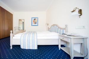 赫茨拉克Hotel Aselager Mühle的卧室配有白色的床和书桌