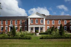 梅里登经典英国庄园酒店的一座大型砖砌建筑,前面设有花园
