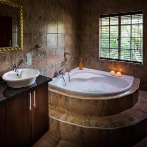 约翰内斯堡Gallo Manor Executive Bed & Breakfast的带浴缸和盥洗盆的大浴室