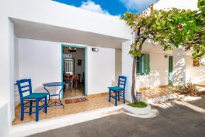 费拉Authentic Santorinian Home Experience的庭院配有蓝色的椅子和桌子