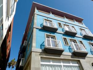 罗萨里奥港塔马塞特酒店的蓝色的建筑,设有白色的窗户和阳台