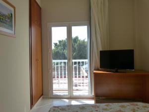罗萨里奥港塔马塞特酒店的一间卧室配有电视和滑动玻璃门