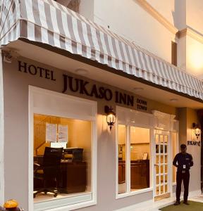 新德里Hotel Jukaso Inn Down Town的站在旅馆前面的警察