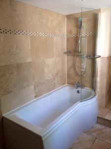 Whittonstall船锚旅馆的带淋浴的浴室配有白色浴缸。