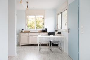 梅伦戈兰מקום בצפון הגולן的白色的厨房配有桌子和水槽