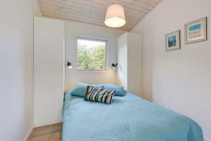 蒙克博Eksklusiv feriebolig med panoramaudsigt的一间卧室配有一张带蓝色床单的床和一扇窗户。