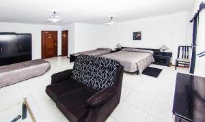 梅利德Hotel Restaurante Xaneiro的一间卧室配有一张床、一把椅子和一张沙发