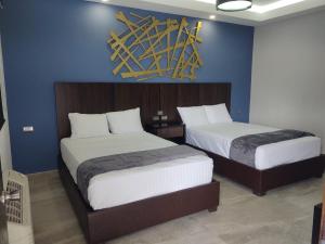 佩尼亚斯科港SAND MAR HOTEL的一间卧室设有两张床和蓝色的墙壁