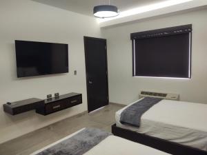 佩尼亚斯科港SAND MAR HOTEL的一间卧室配有两张床和一台平面电视
