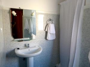 罗萨里奥港塔马塞特酒店的一间带水槽、镜子和淋浴的浴室