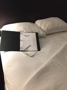 普尔曼美洲狮之地汽车旅馆的坐在白色床边的书