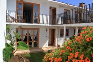 圣克里斯托瓦尔-德拉斯卡萨斯Gaia Guest House的带阳台和橙花的房子