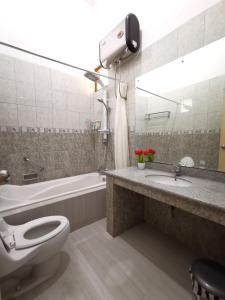 日惹纳瑞斯卡套房民宿的浴室配有卫生间、盥洗盆和浴缸。
