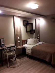 利马Hotel Mundo的一间卧室配有一张床、一张桌子和一把椅子