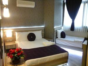 伊兹密尔伊兹密尔奥林匹亚酒店的配有一张床和花瓶的酒店客房