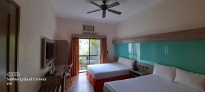 长滩岛长滩岛温德姆麦克罗特酒店的一间卧室配有两张床和吊扇
