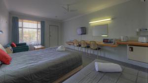 阿米代尔阿卢纳汽车旅馆的酒店客房带一张床、一张桌子和椅子