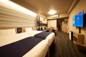 东京MONday Apart Premium AKIHABARA ASAKUSABASHI Sta.的酒店客房设有两张床和一台平面电视。