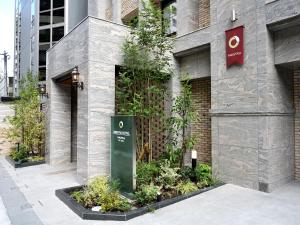 福冈Amistad Hotel Fukuoka的建筑的侧面有标志