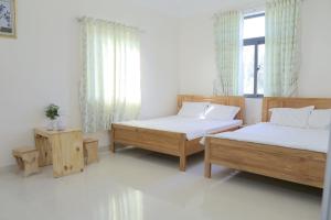 Phú QuýKhách Sạn An Bình Đảo Phú Quý的一间卧室设有两张床和窗户。