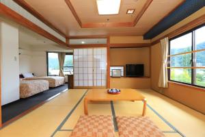 富士河口湖四季之宿富士山酒店的一间卧室配有两张床和一张桌子。