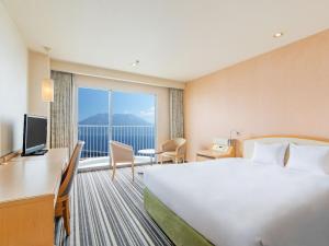 鹿儿岛Art Hotel Kagoshima的酒店客房设有一张床和一个大窗户
