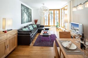 上陶恩Fewo-Obertauern-Steinadler的客厅配有黑色沙发和桌子