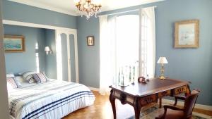西布勒L'Annexe的一间卧室配有一张床、一张书桌和一个窗户。