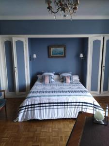 西布勒L'Annexe的一间卧室配有一张带蓝色墙壁的大床