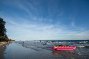 梅尔皮姆Grandbeach Condo Sea view by malai的一条粉红色的木筏躺在海边的海滩上