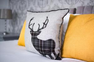 金尤西麦克因尼斯豪斯酒店的枕头和鹿放在枕头旁边,放在枕头旁边