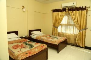 卡拉奇比拉酒店的客房设有两张床和窗户。