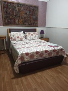 亚历山大Alexander The Great Hotel的一间卧室配有一张带花卉床罩和枕头的床