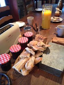 圣拉里苏朗Au Chant Des Marmites的一张木桌,上面放着一盘面包和橙汁