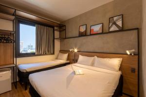 蓬塔格罗萨ibis Ponta Grossa的酒店客房设有两张床和窗户。
