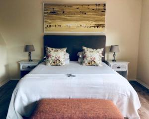 开普敦峰会宫殿宾馆的一间卧室配有一张带2个床头柜的大型白色床