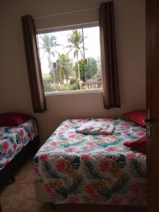 大普拉亚Pousada do Chileno的一间卧室配有一张床,窗户配有床罩
