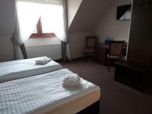 波德古任Gościniec nad Zalewem的酒店客房配有两张床和一张书桌