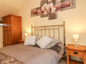 蒂弗顿Crooke Barn的一间卧室配有一张带两个枕头的床