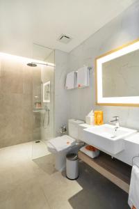 雅加达Harris Suites Puri Mansion的一间带水槽、卫生间和淋浴的浴室