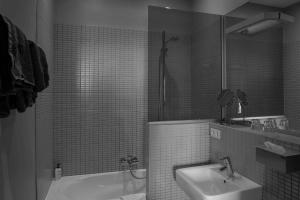 Hoegaarden厄皮库利住宿加早餐旅馆的一间带水槽、浴缸和卫生间的浴室