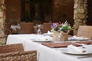 拉加罗维利亚普林西比赛罗乡村酒店的一张桌子,上面有盘子、餐巾和鲜花