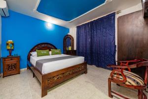 比亚维森西奥Hotel Ayenda Eclipse 1706的一间卧室设有一张床和蓝色的墙壁