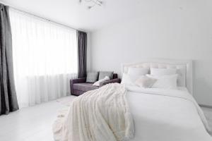 博布鲁伊斯克PaulMarie Apartments on Gor'kogo 41的白色卧室设有一张大床和一张沙发