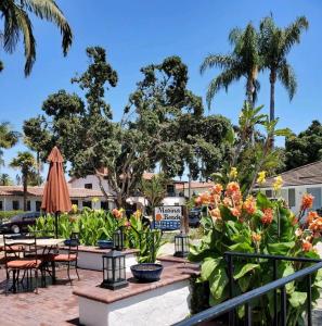 圣巴巴拉玛丽娜海滩汽车旅馆的酒店的露台设有桌椅和棕榈树