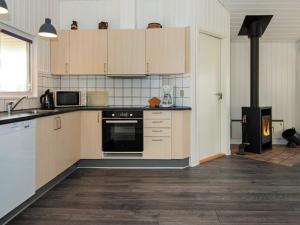 森讷维8 person holiday home in Ringk bing的厨房配有白色橱柜和炉灶。