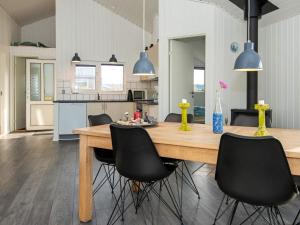 森讷维8 person holiday home in Ringk bing的厨房配有大型木桌和黑色椅子
