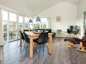 森讷维8 person holiday home in Ringk bing的一间带木桌和椅子的用餐室