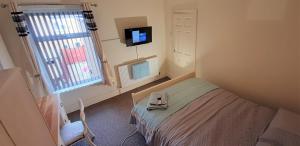 格里姆斯比Grimsby-Cleethorpes Sleeps 7的小房间设有床和电视
